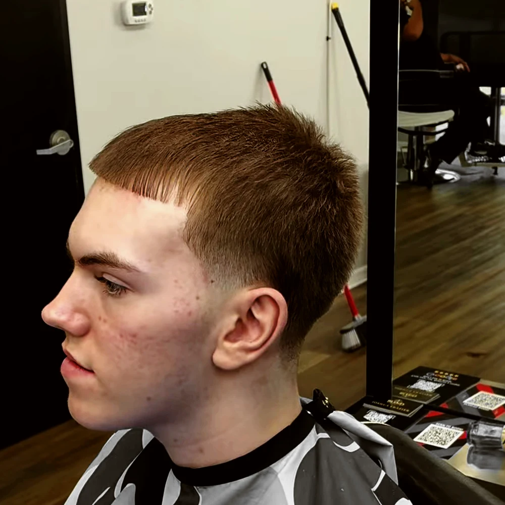 The same client in profile after a short cut with a fringe and a taper